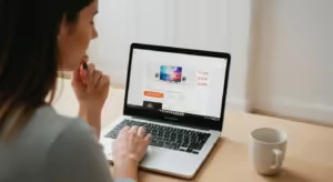 A person looking at a laptop screen displaying a price comparison website with a graph showing the price history of a television.